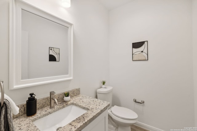 bathroom with hardwood / wood-style floors, vanity, and toilet