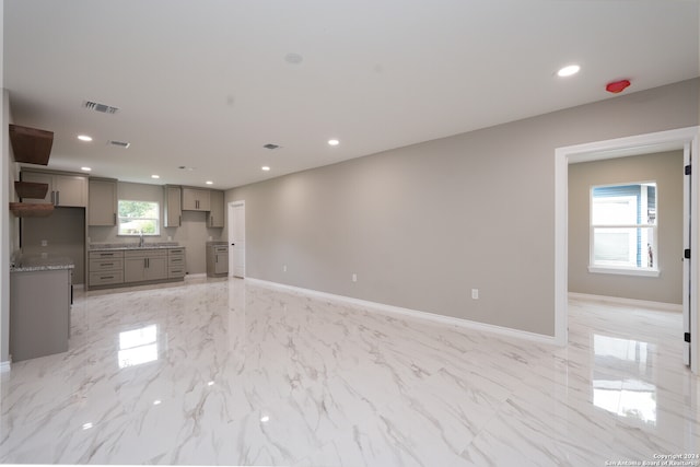 unfurnished living room with a healthy amount of sunlight and sink