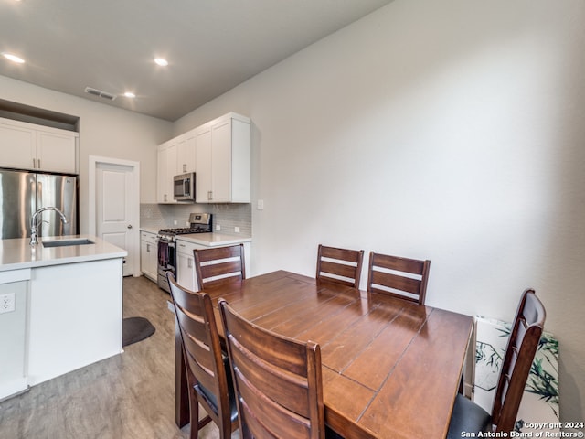 dining space featuring light wood-type flooring and sink