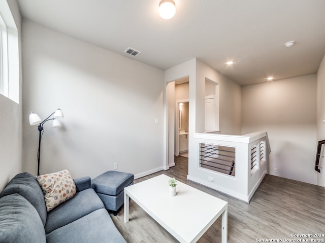 bedroom with ensuite bathroom and light hardwood / wood-style flooring