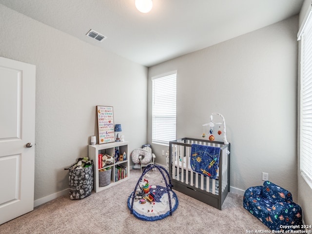 carpeted bedroom featuring a crib