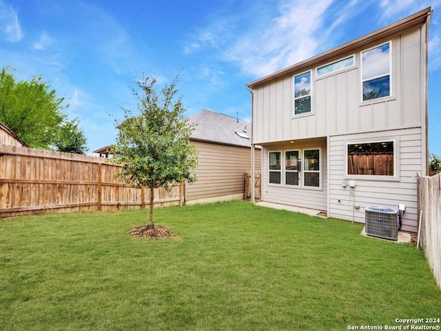 back of property with a lawn and central AC unit