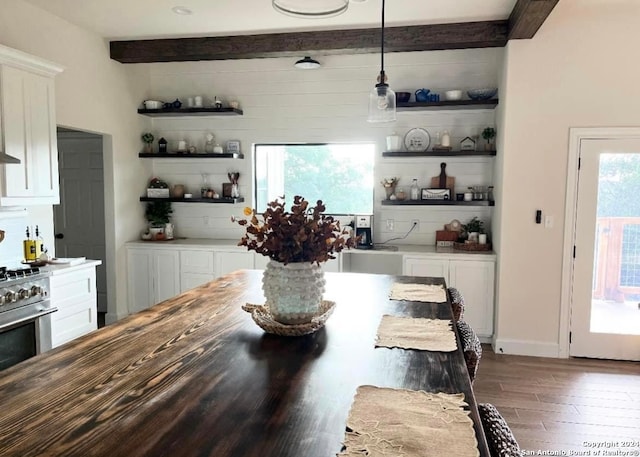 dining area with dark hardwood / wood-style flooring and beamed ceiling