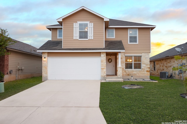 view of front property with a garage, a yard, and cooling unit