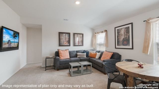 carpeted living room with vaulted ceiling