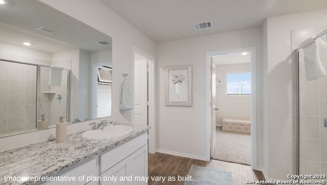 bathroom featuring vanity, an enclosed shower, and hardwood / wood-style flooring