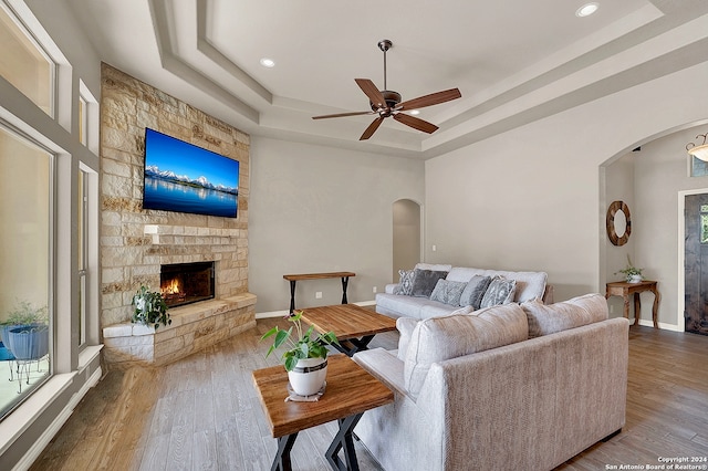 living room featuring a wealth of natural light, wood-type flooring, and a tray ceiling