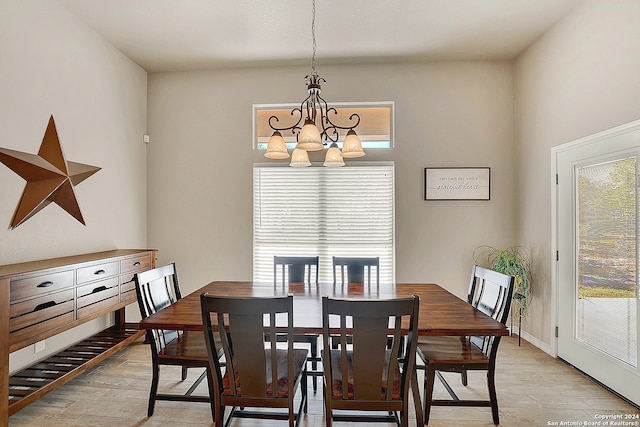 dining area with light wood-type flooring and a notable chandelier