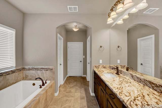 bathroom featuring vanity and tiled tub