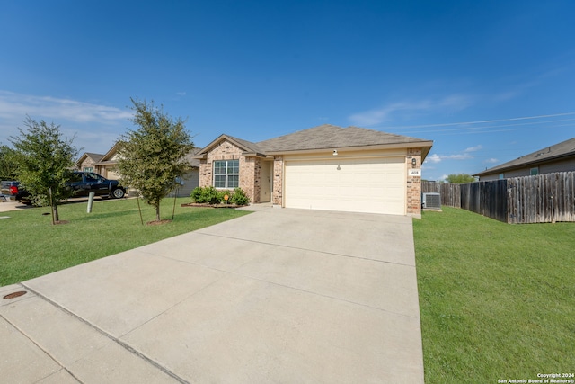 ranch-style house featuring a garage, cooling unit, and a front lawn