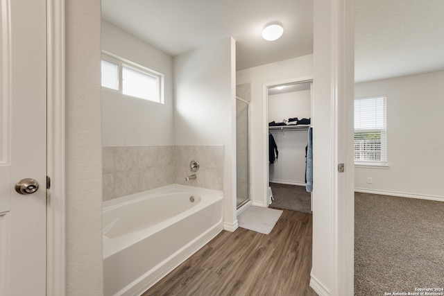 bathroom with wood-type flooring and plus walk in shower