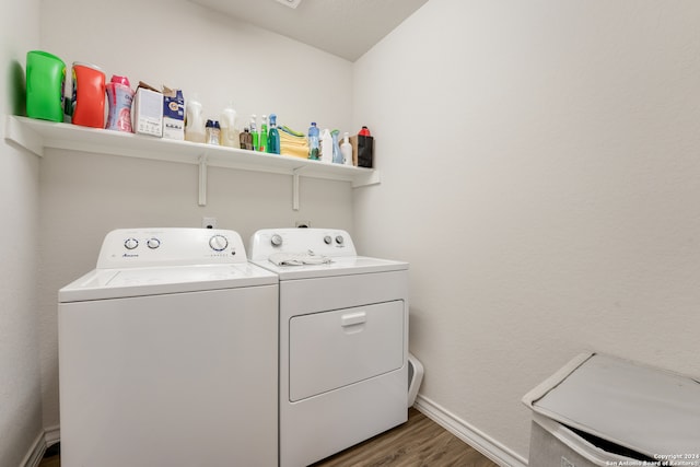 laundry area featuring washing machine and clothes dryer and dark hardwood / wood-style floors