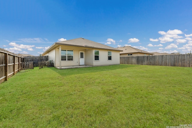 back of house featuring a patio and a lawn