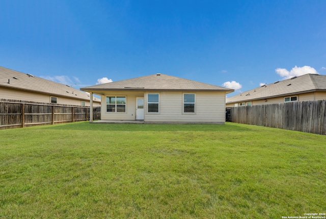 back of house with a lawn