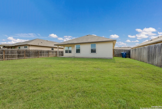 rear view of house featuring a yard