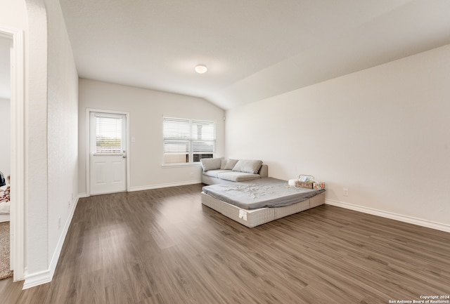 unfurnished bedroom with dark hardwood / wood-style flooring and vaulted ceiling