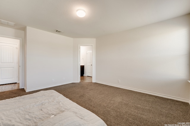 unfurnished bedroom with dark colored carpet