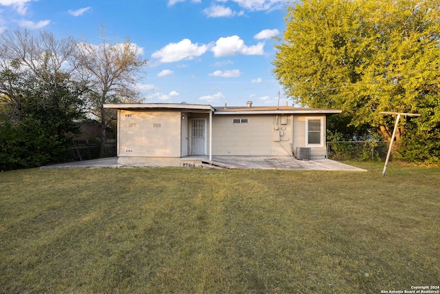 back of property featuring central air condition unit, a yard, and a patio