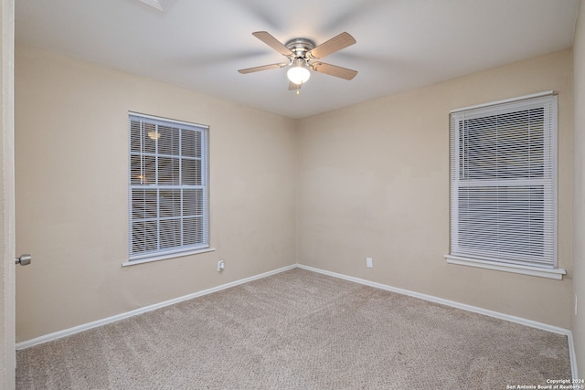 empty room featuring light colored carpet and ceiling fan