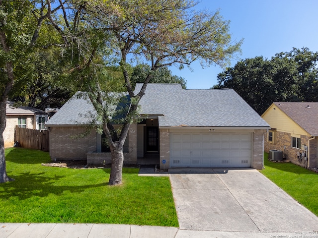 ranch-style house with central AC unit, a garage, and a front yard