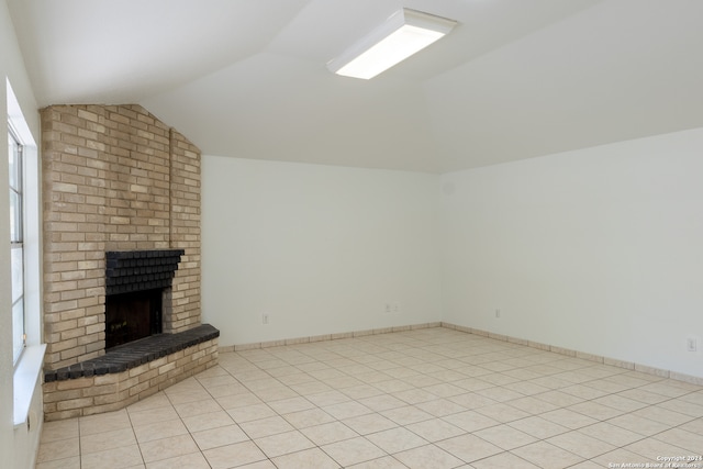 unfurnished living room with vaulted ceiling, light tile patterned floors, and a fireplace