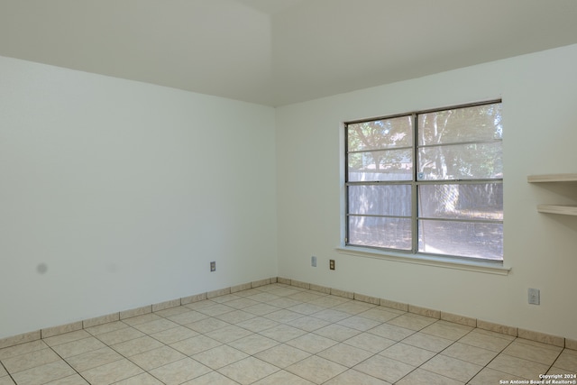 spare room featuring light tile patterned flooring and a healthy amount of sunlight