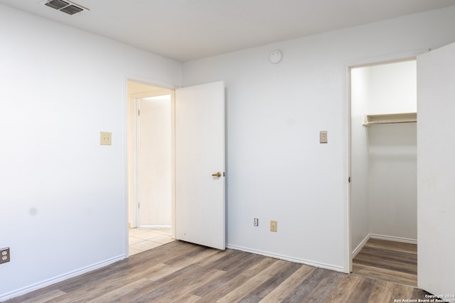 unfurnished bedroom featuring a closet and hardwood / wood-style floors