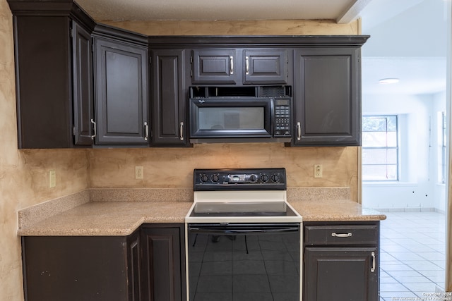 kitchen with decorative backsplash, tile patterned flooring, and electric range