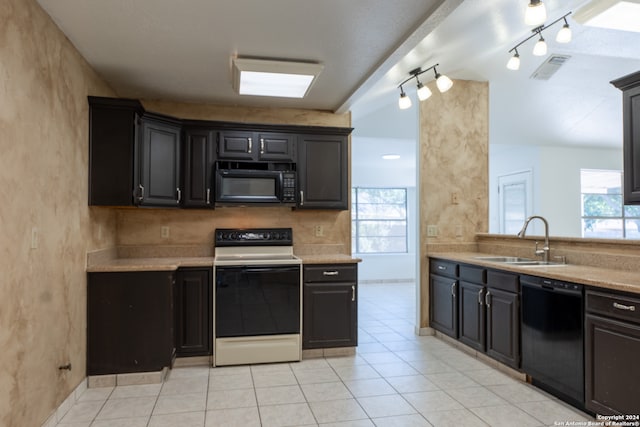 kitchen with a healthy amount of sunlight, sink, black appliances, and rail lighting