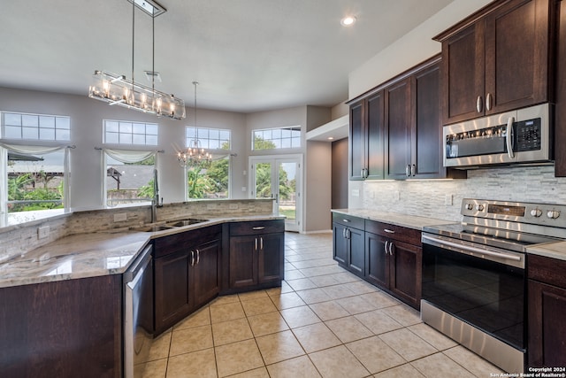 kitchen featuring a wealth of natural light, stainless steel appliances, sink, and decorative light fixtures