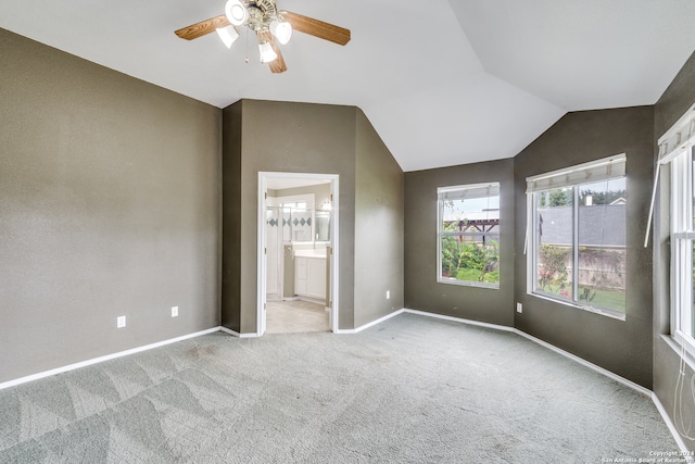 unfurnished bedroom featuring ensuite bath, lofted ceiling, light carpet, and ceiling fan