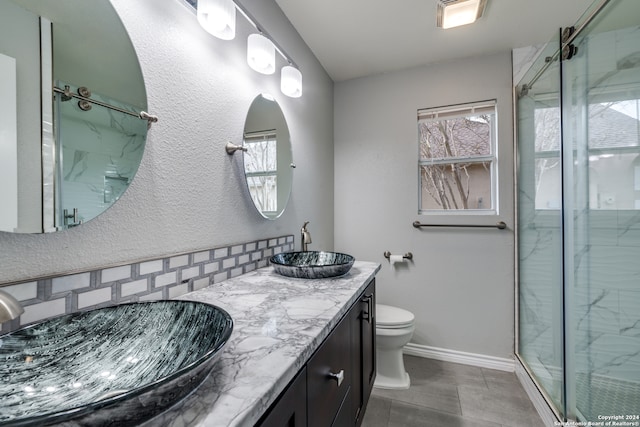 bathroom with vanity, tile patterned floors, toilet, and a shower with door