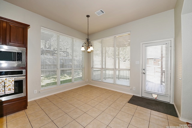 unfurnished dining area with a chandelier and light tile patterned floors