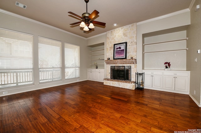 unfurnished living room with built in shelves, dark wood-type flooring, and a healthy amount of sunlight