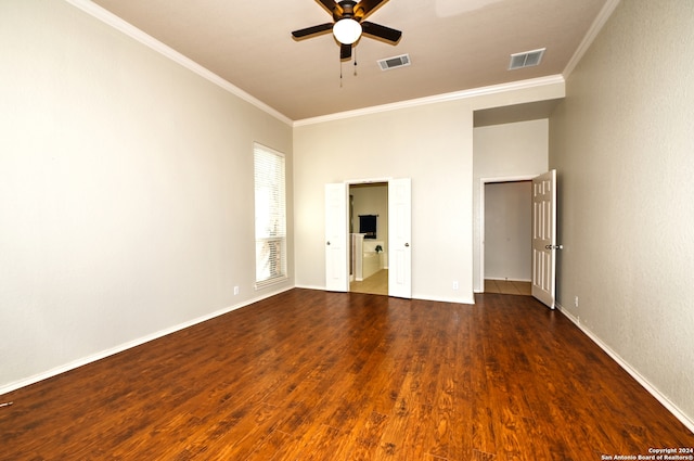 spare room with dark wood-type flooring, ceiling fan, and ornamental molding