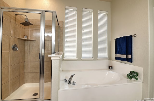 bathroom featuring shower with separate bathtub