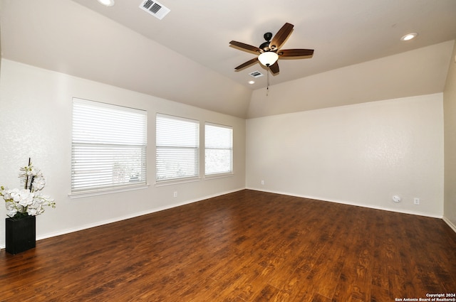 spare room with dark wood-type flooring, vaulted ceiling, and ceiling fan