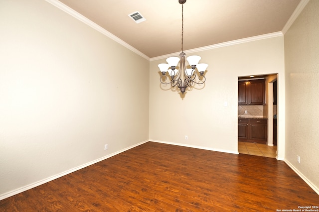 unfurnished room featuring ornamental molding, an inviting chandelier, and dark hardwood / wood-style floors