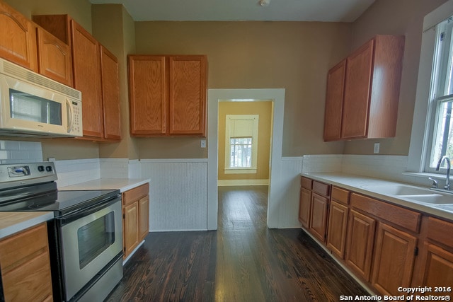 kitchen featuring dark hardwood / wood-style flooring, stainless steel range with electric stovetop, and sink