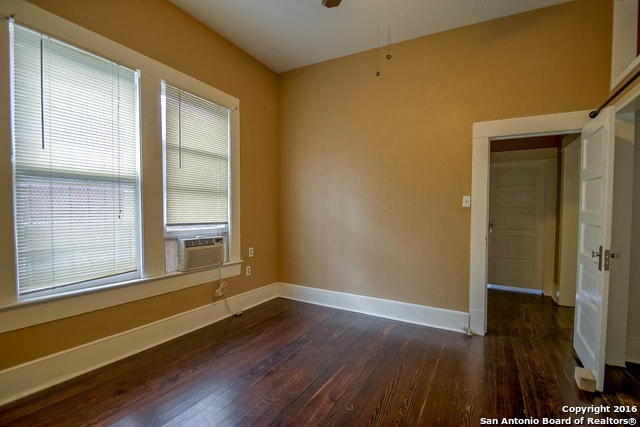 empty room featuring dark wood-type flooring and cooling unit