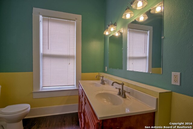 bathroom with hardwood / wood-style floors, vanity, and toilet