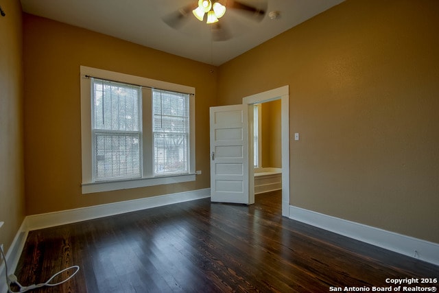 empty room featuring ceiling fan and dark hardwood / wood-style floors