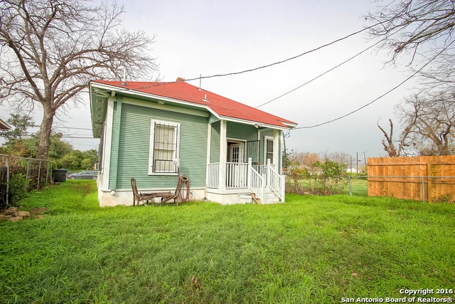 rear view of property with a yard