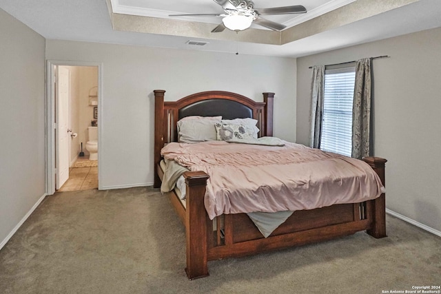 carpeted bedroom with ceiling fan, connected bathroom, crown molding, and a tray ceiling