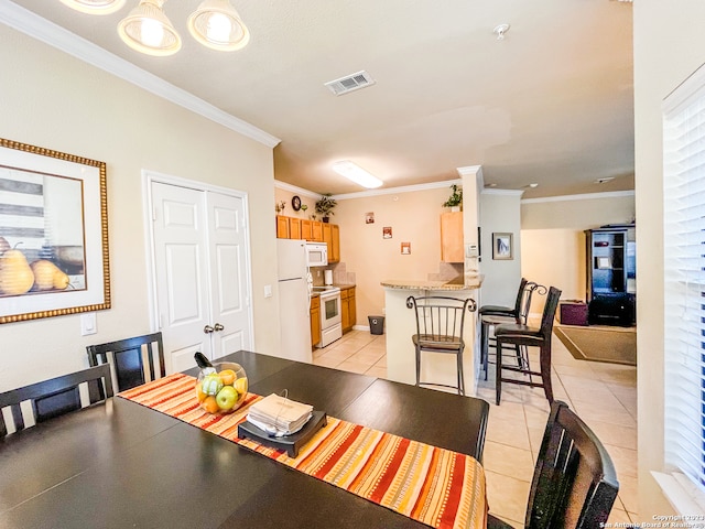 dining space featuring light tile patterned floors and crown molding