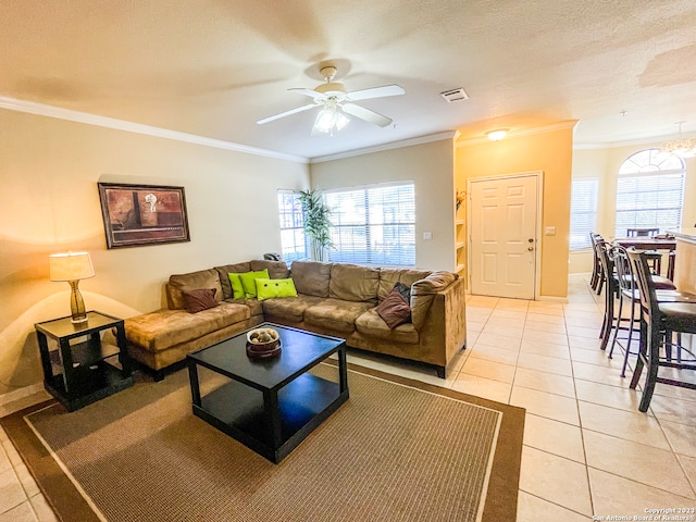 living room with a textured ceiling, light tile patterned floors, ceiling fan, and crown molding