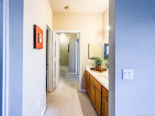 hall featuring a textured ceiling and light carpet