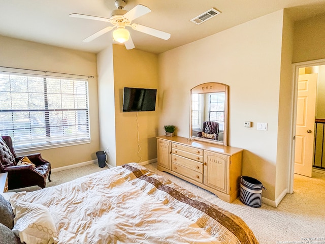 bedroom featuring multiple windows, light carpet, and ceiling fan