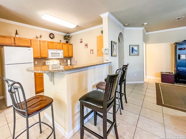 kitchen with a breakfast bar, kitchen peninsula, ornamental molding, white appliances, and stone counters