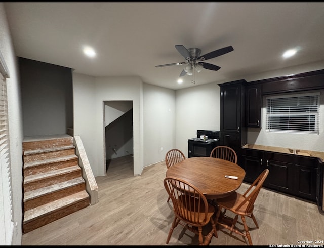 dining area with light wood-type flooring and ceiling fan